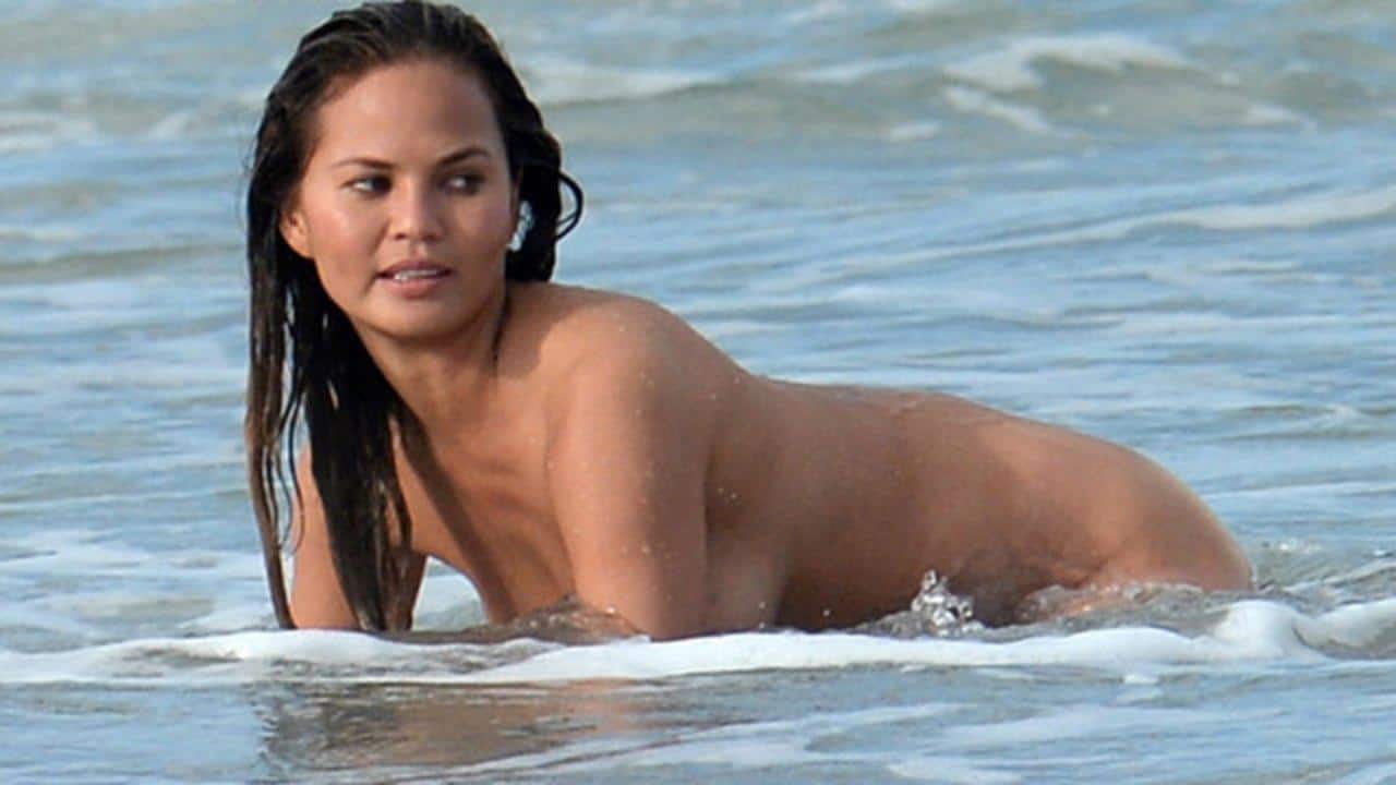 Chrissy Teigen naked in the ocean on all fours