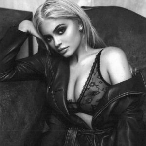 a blonde kylie jenner wearing a see through bra and showing off nipple ring