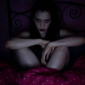 shadowy hacked pic of kat dennings in bed naked staring fiercely into the camera