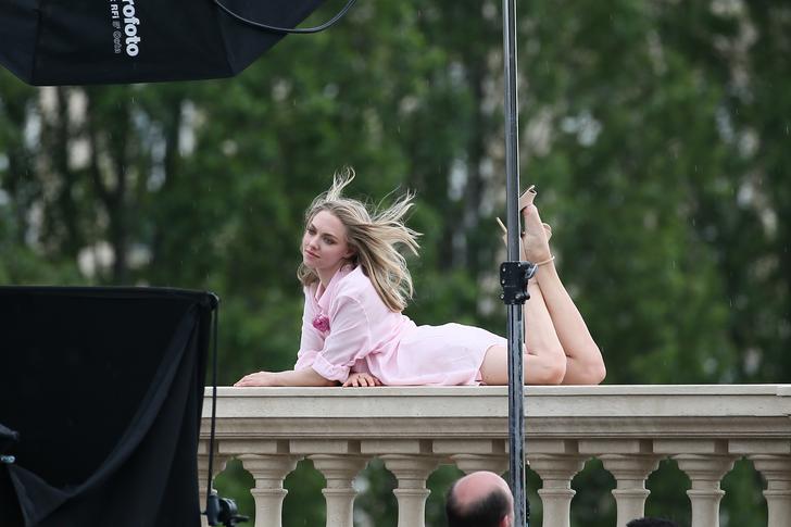 gorgeous pic of amanda seyfried laying on paris balcony with legs in the air and her hair blowing in the wind