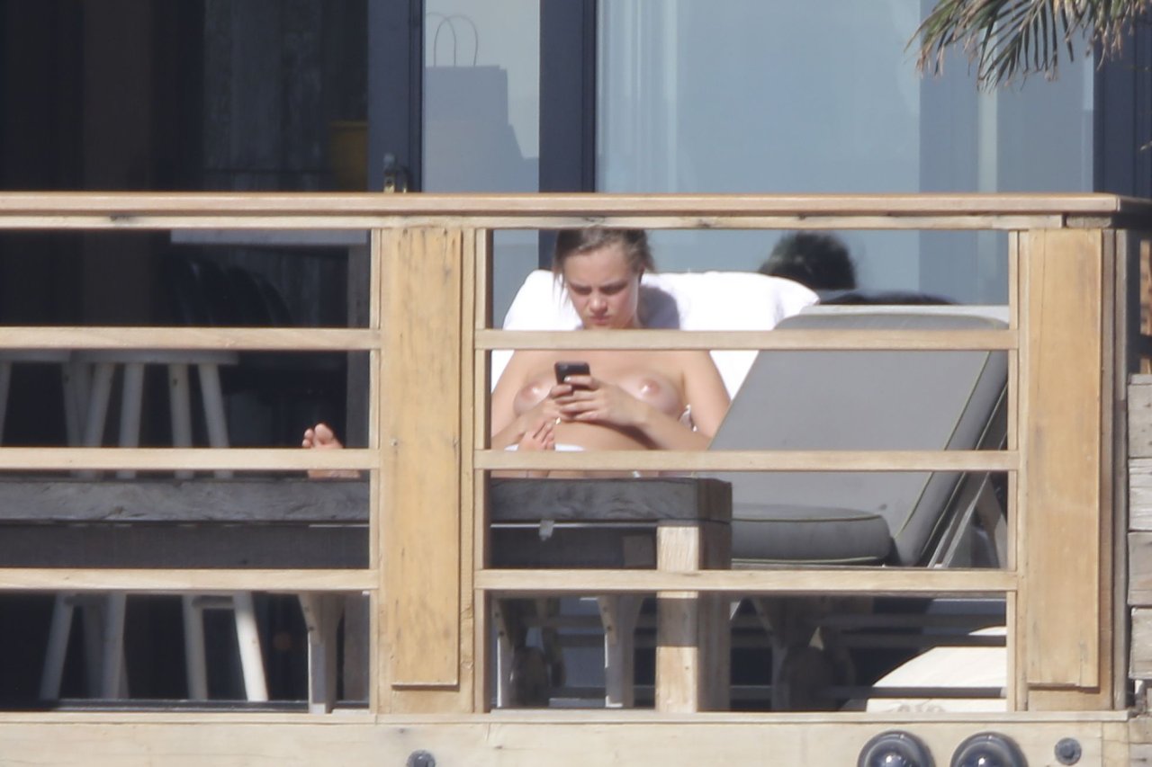 Cara Delevingne topless sunbathing